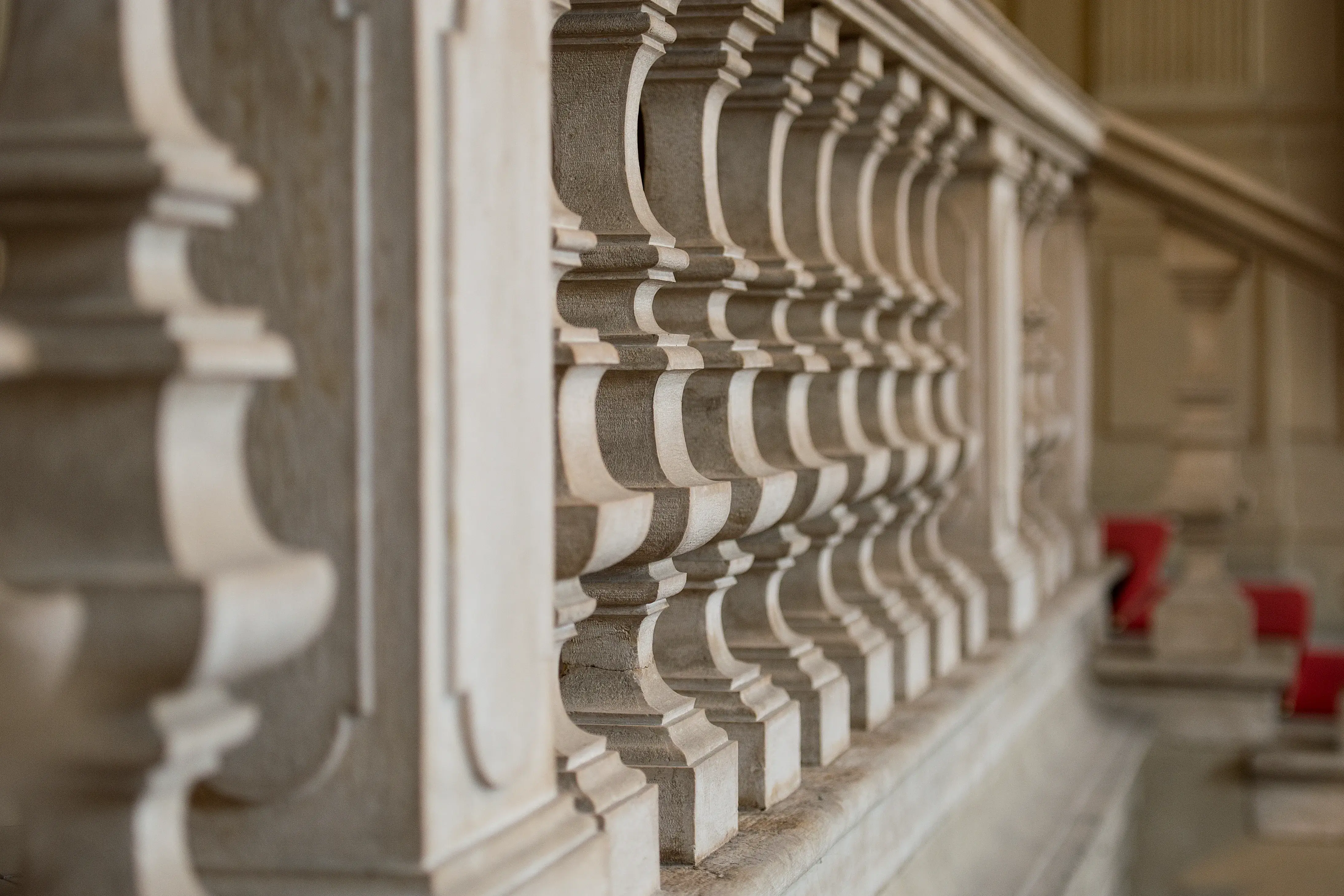 Balaustra dello scalone di Palazzo Santangelo: gli elementi in pietra si ripetono e sfumano in profondità.