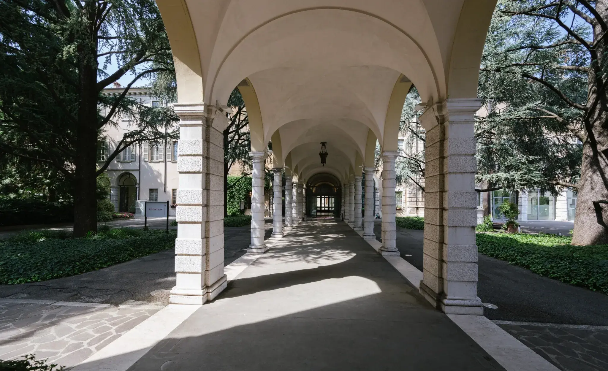 Portico colonnato di Palazzo Santangelo a Brescia, con il percorso segnato dalla luce e dalle ombre